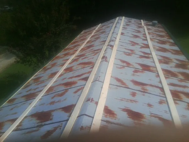 Rusted metal roof panels with new wood purlins before replacement — Storm Damage Roof Repair in Yale by Roofing Brothers